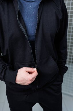 Bir adam şık mavi bir kazak giyerken görüldü. Parlak siyah bir ceketle eşleştirilmiş. Havalı bir dış giysi sergiliyor.