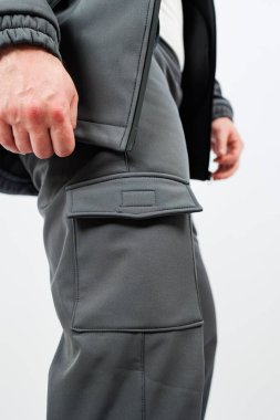 Şık bir kargo pantolonu giyen, benzersiz ceplerini ve pratik tasarımlarını vurgulayan birini gösteren detaylı bir yakın çekim görüntüsü.