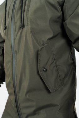 Bir kişi canlı yeşil bir ceket giyiyor. İçinde şık, siyah bir fermuar var. Açık hava aktiviteleri için mükemmel.