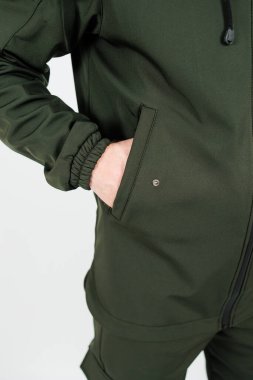 Canlı yeşil ceketli bir adamın iki eli de ceketinin cebinde rahatça dinleniyor.