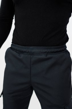 Bireyin üzerinde siyah bir gömlek ve ona uyan siyah bir pantolon var. Üniforma ve şık bir görünüm yaratıyor.