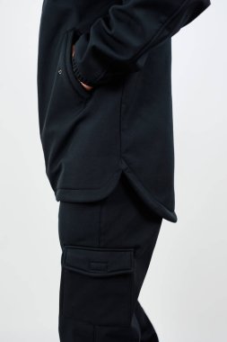 Siyah kargo pantolonu giymiş bir insan ellerini pantolonunun cebine sokup rahatlamış görünüyor.