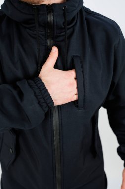 Tarz ve pozitiflik gösterirken kendine güvenen siyah ceketli bir adam başparmak işareti yapıyor.