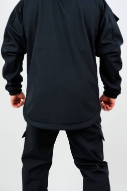 Siyah gömlekli bir bireyin arkası. Aynı siyah pantolona sahip. Parlak, üniformalı biri.