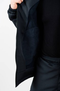 Şu anda bir kişi şık siyah bir ceket giyiyor ve şık bir siyah pantolon giyiyor. Tek renkli bir görünüm yaratıyor.