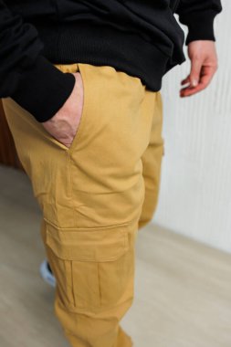 Şık bir siyah kapüşonluyla mükemmel bir şekilde eşleşen bej kargo pantolonları keşfedin.