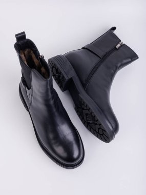 Beyaz arka planda hakiki deriden yapılmış düz tabanlı kadın botları. Sonbahar gündelik kadın ayakkabıları.