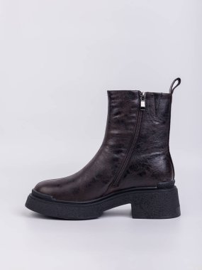 Beyaz arka planda hakiki deriden yapılmış düz tabanlı kadın botları. Sonbahar gündelik kadın ayakkabıları.