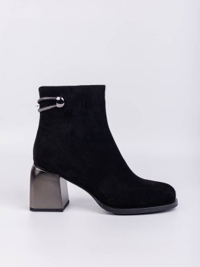 Zarif kadın çizmeleri. Siyah topuklu, hakiki deri ayakkabılar. Beyaz arka planda bağlayıcılar var. Her gün için şık sonbahar kadın ayakkabıları.