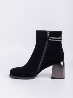 Zarif kadın çizmeleri. Siyah topuklu, hakiki deri ayakkabılar. Beyaz arka planda bağlayıcılar var. Her gün için şık sonbahar kadın ayakkabıları.