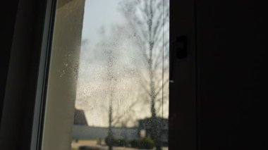 Cam silici. Oda servisi. Sabun solüsyonu pencereye sıçrar. Pencere temizleyicisi. Ev hanımı pencereyi temizler..