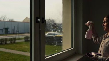 Cam silici. Oda servisi. Sabun solüsyonu pencereye sıçrar. Pencere temizleyicisi. Ev hanımı pencereyi temizler..