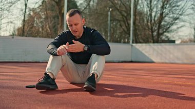 Bir adam açık hava spor sahasında spor yapıyor. Yazın vücut geliştirme egzersizleri yapan bir adam var..