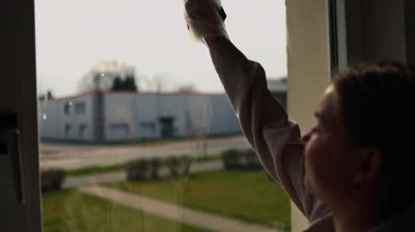 Cam silici. Oda servisi. Sabun solüsyonu pencereye sıçrar. Pencere temizleyicisi. Ev hanımı pencereyi temizler..