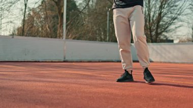 Bir adam açık hava spor sahasında spor yapıyor. Yazın vücut geliştirme egzersizleri yapan bir adam var..