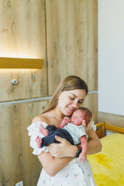 Bir anne, yeni doğan bebeğini huzurlu bir hastane ortamında neşeyle kucaklar. Yeni hayatın mucizesini ve anne sevgisindeki derin bağları güzel bir şekilde gözler önüne serer.