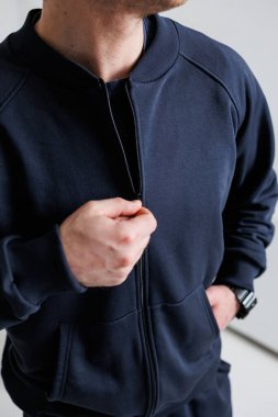 Donanma fermuarlı ceketi olan şık bir adam modern atletizm kıyafetlerinde kusursuz bir konfor ve modern modaya uyum sağlıyor.