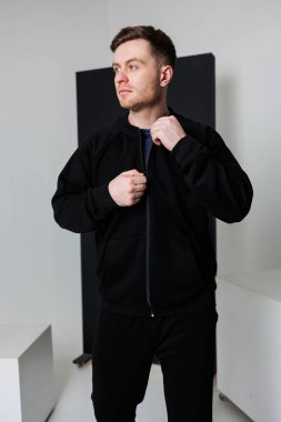 Canlı bir stüdyoda, genç bir adam şık bir siyah spor ceket sergiliyor. Benzersiz tarzını vurguluyor ve şık görünüşüyle herkesi büyülüyor.