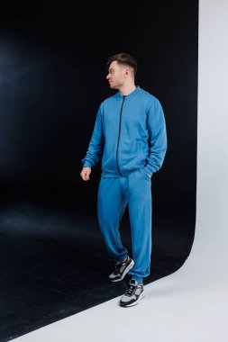 Moda mavisi eşofman giyen bir model. Spor ve günlük geziler için mükemmel. Antrenmanlar ya da gevşetilmiş günler için ideal konfor