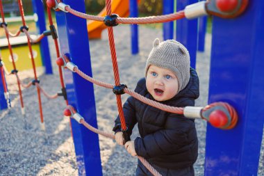 Çocuk dışarıda yürüyor. Çocuk bahçesinde yürüyüş yapan mutlu bir çocuk. Çocuk gelişimi, çocuğun sağlıklı yaşam tarzı. Çocuk sonbahar yürüyüşüne çıkmış. Şehir parkında neşeli bir çocuk.