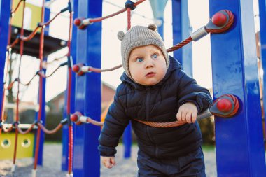 Çocuk dışarıda yürüyor. Çocuk bahçesinde yürüyüş yapan mutlu bir çocuk. Çocuk gelişimi, çocuğun sağlıklı yaşam tarzı. Çocuk sonbahar yürüyüşüne çıkmış. Şehir parkında neşeli bir çocuk.