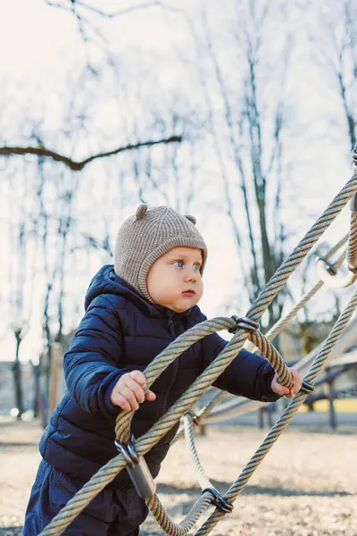 Çocuk dışarıda yürüyor. Çocuk bahçesinde yürüyüş yapan mutlu bir çocuk. Çocuk gelişimi, çocuğun sağlıklı yaşam tarzı. Çocuk sonbahar yürüyüşüne çıkmış. Şehir parkında neşeli bir çocuk.