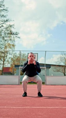 Açık hava parkında spor yapan genç bir atletik. Sağlıklı bir yaşam tarzı. Spor kıyafetli bir adam fiziksel egzersiz yapıyor..