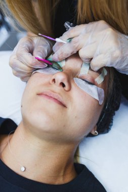 Kirpik yapıştırma yöntemi. Kirpiklerin botoksla kaplanması sırasında bir kadının yüzünün yakın çekimi. Kirpik bakımı: kaldırma ve kıvırma, kaplama ve kirpik uzantıları.