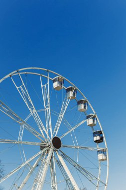 Mavi gökyüzüne karşı büyük bir dönme dolap. Dönme dolapta kamaralar.