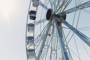 Şehri yukarıdan seyretmek için bir cazibe. Mavi gökyüzüne karşı kamaraları olan büyük bir dönme dolap havalanıyor. Kapalı kamaralı bir dönme dolap..