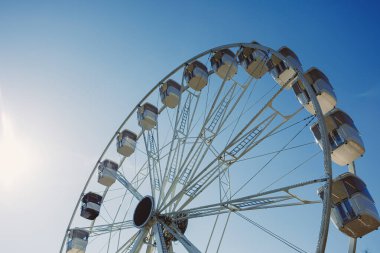 Şehri yukarıdan seyretmek için bir cazibe. Mavi gökyüzüne karşı kamaraları olan büyük bir dönme dolap havalanıyor. Kapalı kamaralı bir dönme dolap..