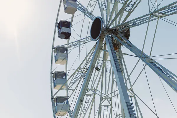 Şehri yukarıdan seyretmek için bir cazibe. Mavi gökyüzüne karşı kamaraları olan büyük bir dönme dolap havalanıyor. Kapalı kamaralı bir dönme dolap..