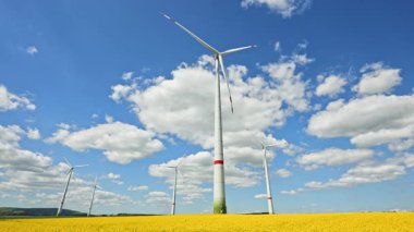 Rüzgar türbinlerindeki eko-enerji alanı. Alternatif enerji türbinleri ve mavi gökyüzünün arka planında bıçaklar. Rüzgar çiftliği ağır çekim. Yel değirmenlerinin siluetleri.