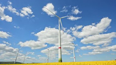 Rüzgar türbinlerindeki eko-enerji alanı. Alternatif enerji türbinleri ve mavi gökyüzünün arka planında bıçaklar. Rüzgar çiftliği ağır çekim. Yel değirmenlerinin siluetleri.