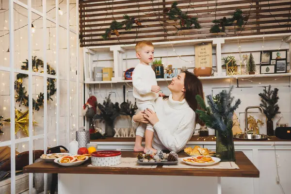 Anne ve küçük oğlu Noel 'de evde, çocuk annesine gülümsüyor, tebrik ediyor ve beklenmedik hediyeler veriyor. Kadın anne, oğlundan doğum gününde hediye alır. Aile tatili, aşk konsepti