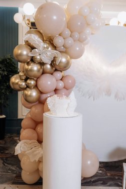 Bir çocuğun vaftizini kutlamak için beyaz pasta. Beyaz kanatlı tatlı pasta. Bir çocuğun vaftiz töreni için fotoğraf bölgesi.