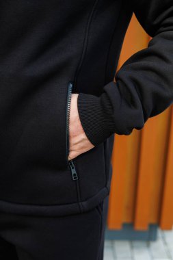 Bu şık ve gösterişli siyah spor ceketin desenli kolları ve fermuarlı cepleri var. Açık hava aktiviteleri için mükemmel bir seçim.