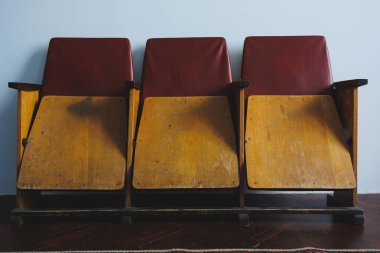 Bu çarpıcı görüntü, klasik kırmızı ve sarı dizaynlı, retrotemalı ev dekorasyonu ve sinematik ayarlar için mükemmel klasik tiyatro koltuklarından oluşan büyüleyici bir üçlüyü gösteriyor.