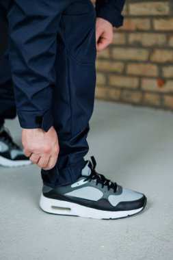 Modern bir şehir ortamında şık atletik pantolonlar giyerek şık bir birey ayakkabısını ayarlar. Yaşam tarzı ve fitness temaları için mükemmel.