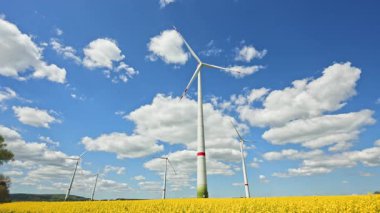 Rüzgar türbinlerindeki eko-enerji alanı. Alternatif enerji türbinleri ve mavi gökyüzünün arka planında bıçaklar. Rüzgar çiftliği ağır çekim. Yel değirmenlerinin siluetleri.