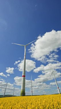 Rüzgar türbinlerindeki eko-enerji alanı. Alternatif enerji türbinleri ve mavi gökyüzünün arka planında bıçaklar. Rüzgar çiftliği ağır çekim. Yel değirmenlerinin siluetleri.
