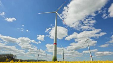 Rüzgar türbinlerindeki eko-enerji alanı. Alternatif enerji türbinleri ve mavi gökyüzünün arka planında bıçaklar. Rüzgar çiftliği ağır çekim. Yel değirmenlerinin siluetleri.