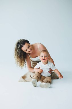 Sıcak ve davetkar bir stüdyonun atmosferinde, sevgi dolu bir anne kıkırdayan çocuğuyla mutlu bir şekilde meşgul olur, paylaştıkları değerli aile bağlarını güzelce gözler önüne serer.