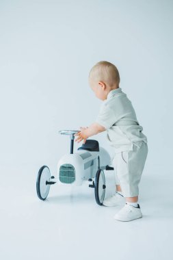 Parlak bir stüdyoda, neşeli bir çocuk büyüleyici bir eski model oyuncak arabayla neşe içinde oynuyor, genç keşiflerin ve neşeli masumiyetin güzelliğini somutlaştırıyor.