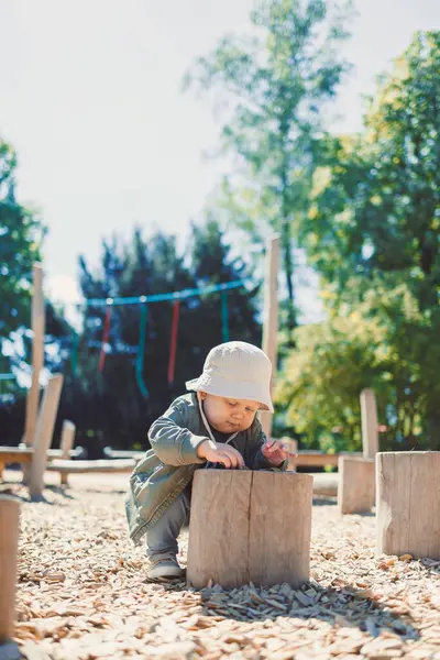 Çocuk parkta koşuyor ve oyun oynuyor. Çocuklar için şık çocuk kıyafetleri. Parkta yeşil çimlerin üzerinde güneşli bir yaz gününün tadını çıkaran 2 yaşında bir çocuk. Doğadaki çocuklar için etkinlikler.