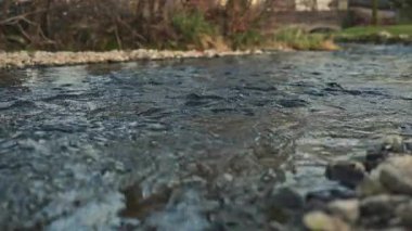 Bir pınardan akan su. Güçlü nehir suyu akıntısı. Nehirdeki taşların üzerinden akan su..