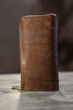 Bu zarif kahverengi deri cüzdan, fermuar kapanışı içeriyor, para ve kartları verimli bir şekilde düzenlemek için stil ve pratikliği birleştiriyor, bu da onu zamansız bir aksesuar haline getiriyor.