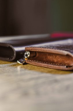 Prestijli deri cüzdanlarımızın zarafetini keşfedin. Zarif işçilik ve incelik içeren kırsal ahşap bir yüzeye karşı onların cazibesini artırıyor.