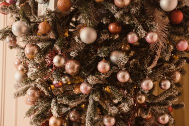 Renkli süslemelerle parıldayan güzel dekore edilmiş bir Noel ağacı ve büyüleyici, şekerli yapraklar, keyifli ve sıcak bir bayram havası yaratır.