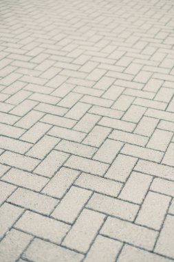 Bu resim, ringa kemiği desenli kaldırımın detaylı bir görüntüsünü, yumuşak nötr tonlarını ve çeşitli peyzaj projeleri için uygun temiz bir tasarımı sergiliyor..